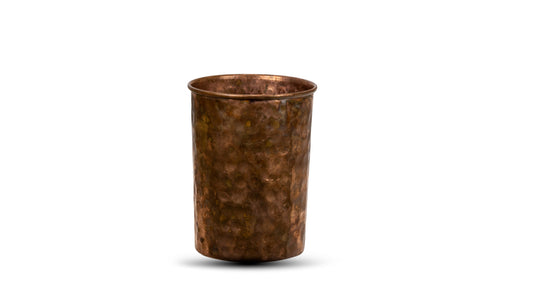 A set of one copper water jug and six copper tumblers. The copperware has a handcrafted and polished finish with a rustic appearance.
